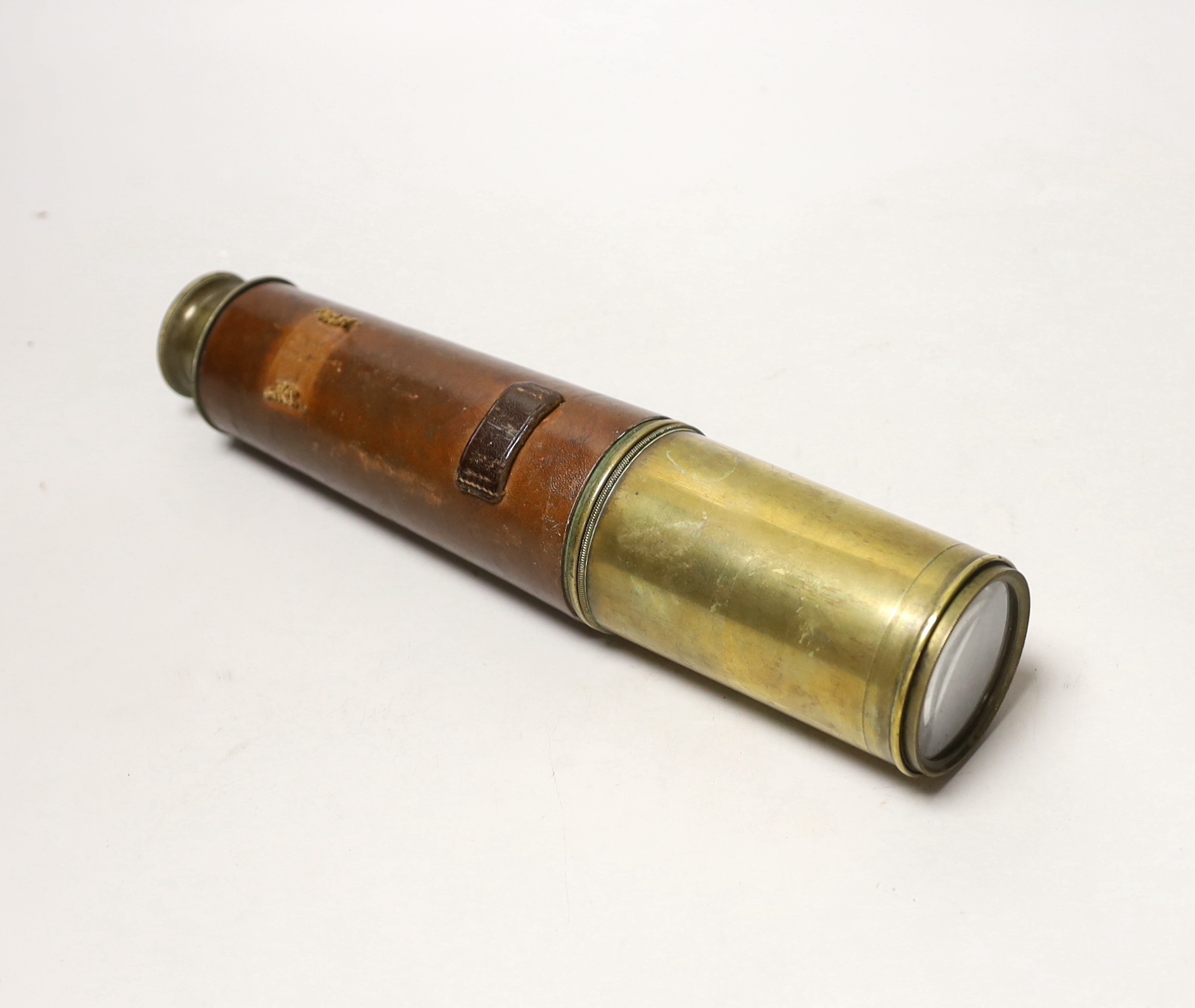 A WWI three draw brass telescope with sun shade and leather outer cover by Taylor Taylor Hobson Ltd.